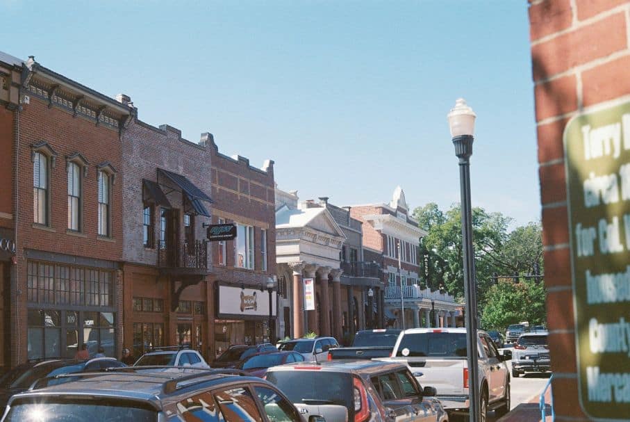 A picturesque street view of a small town reveals historic brick buildings, parked cars, and a row of charming shops under the bright blue sky, presenting a perfect post template for capturing timeless community vibes. A picturesque street view of a small town reveals historic brick buildings, parked cars, and a row of charming shops under the bright blue sky, presenting a perfect post template for capturing timeless community vibes.
