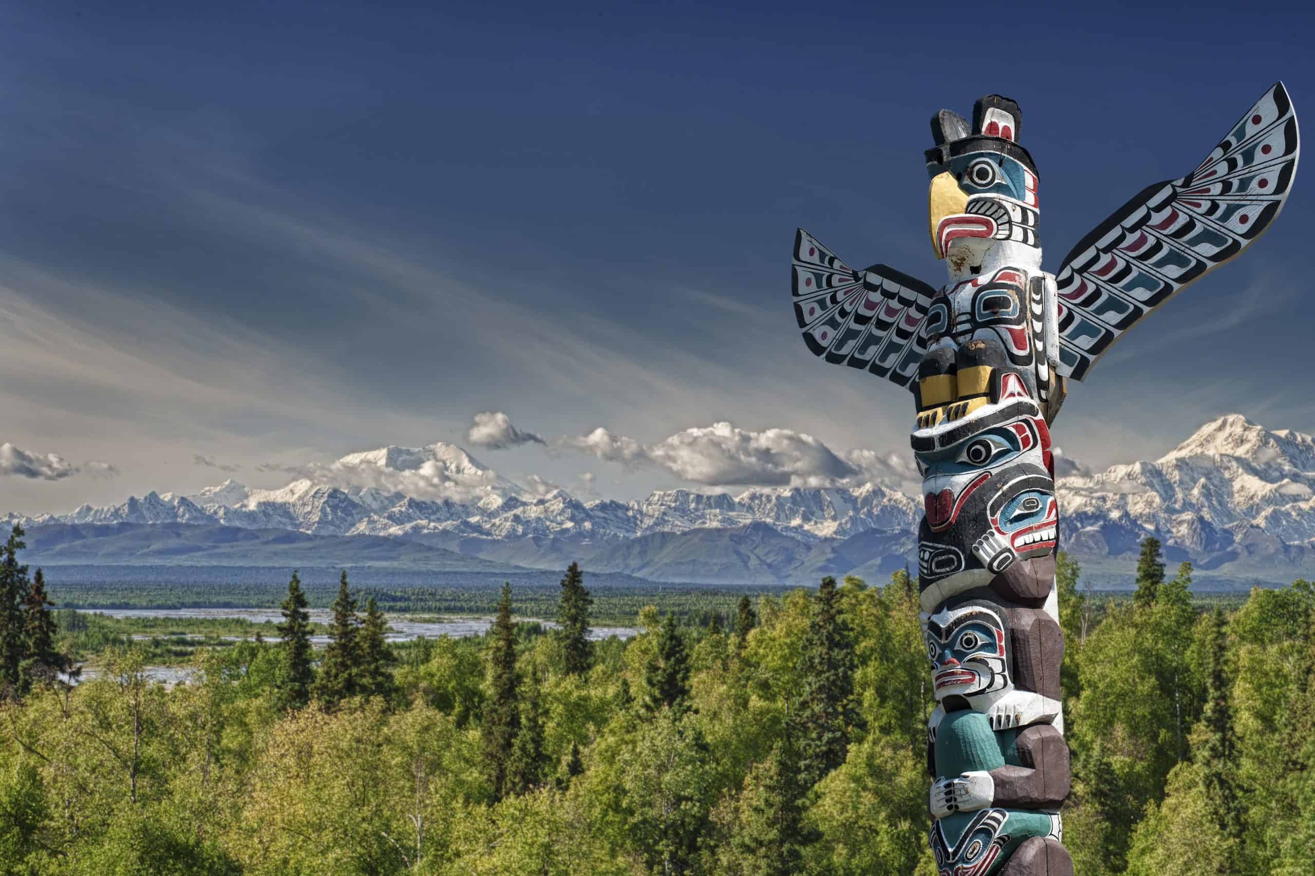 A totem wood pole in mountain background